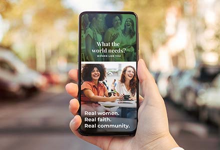 Person holding phone with social media graphics with the headline: What world needs? Women like you.