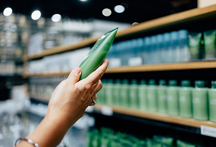 Woman's hand holding a bottle in a store