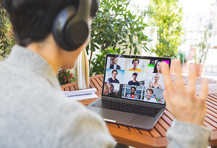 Photo of a woman on her patio participating in a work video call