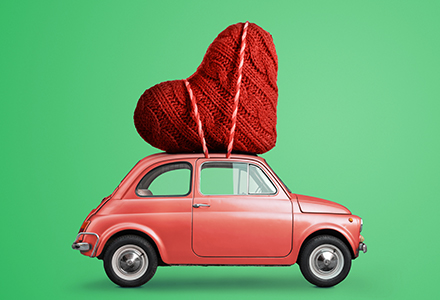 Toy car with knitted heart strapped to the top