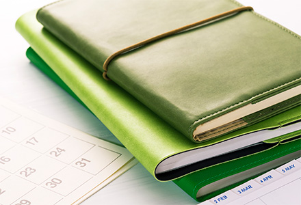 Stack of notebooks next to a calendar