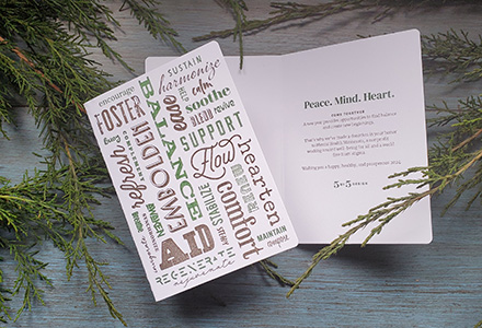 Holiday card on evergreen branches. Inside reads: Peace. Mind. Heart.