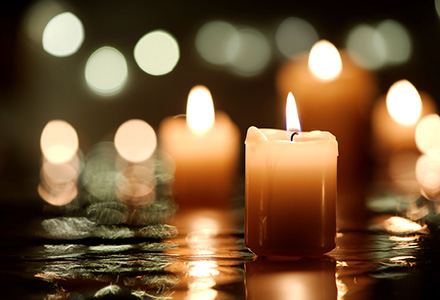 Candles sitting in water with the light reflecting 
