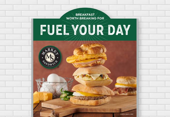 Photo of a food warmer header advertising Market Sandwich breakfast sandwiches. Headline: Fuel Your Day, Breakfast worth breaking for