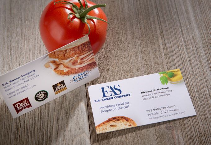 Business card for E.A. Sween on a wood background with a tomato