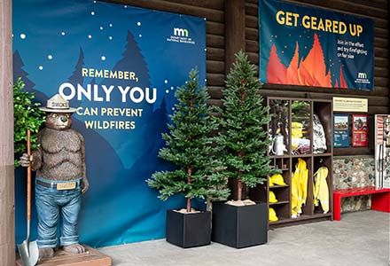 Selfie station and gear station with Smokey Bear statue at the DNR Fire Prevention area at the Minnesota State Fair
