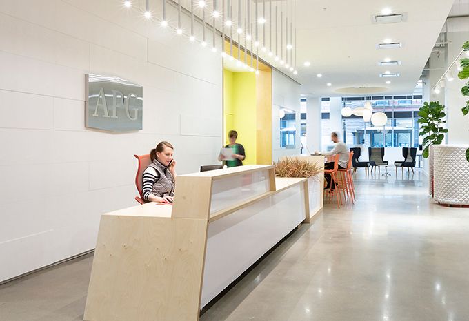 Photo of a reception area for APG Office Furnishings with a large metal logo on the wall