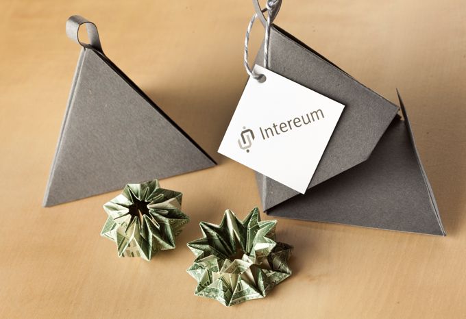 Dollar bills folded into origami shapes with gift packaging from Intereum